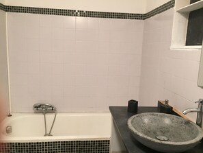 Tina con regadera, secadora de cabello, toallas, papel de baño