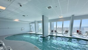 Una piscina interior con vistas despejadas del horizonte urbano a través de amplios ventanales.