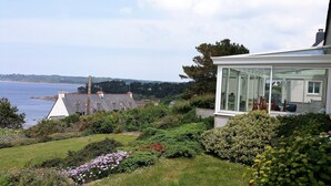 A modern house with a conservatory, a well-maintained garden, and a view of the sea. - VERY COMFORTABLE HOUSE EXCEPTIONAL VIEW SEA - GRAND GARDEN CLOS 8 people  (Trédrez-Locquémeau)
