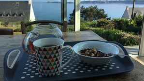 A table with a tray holding a mug, a glass pitcher, and a bowl of cereal. - VERY COMFORTABLE HOUSE EXCEPTIONAL VIEW SEA - GRAND GARDEN CLOS 8 people  (Trédrez-Locquémeau)