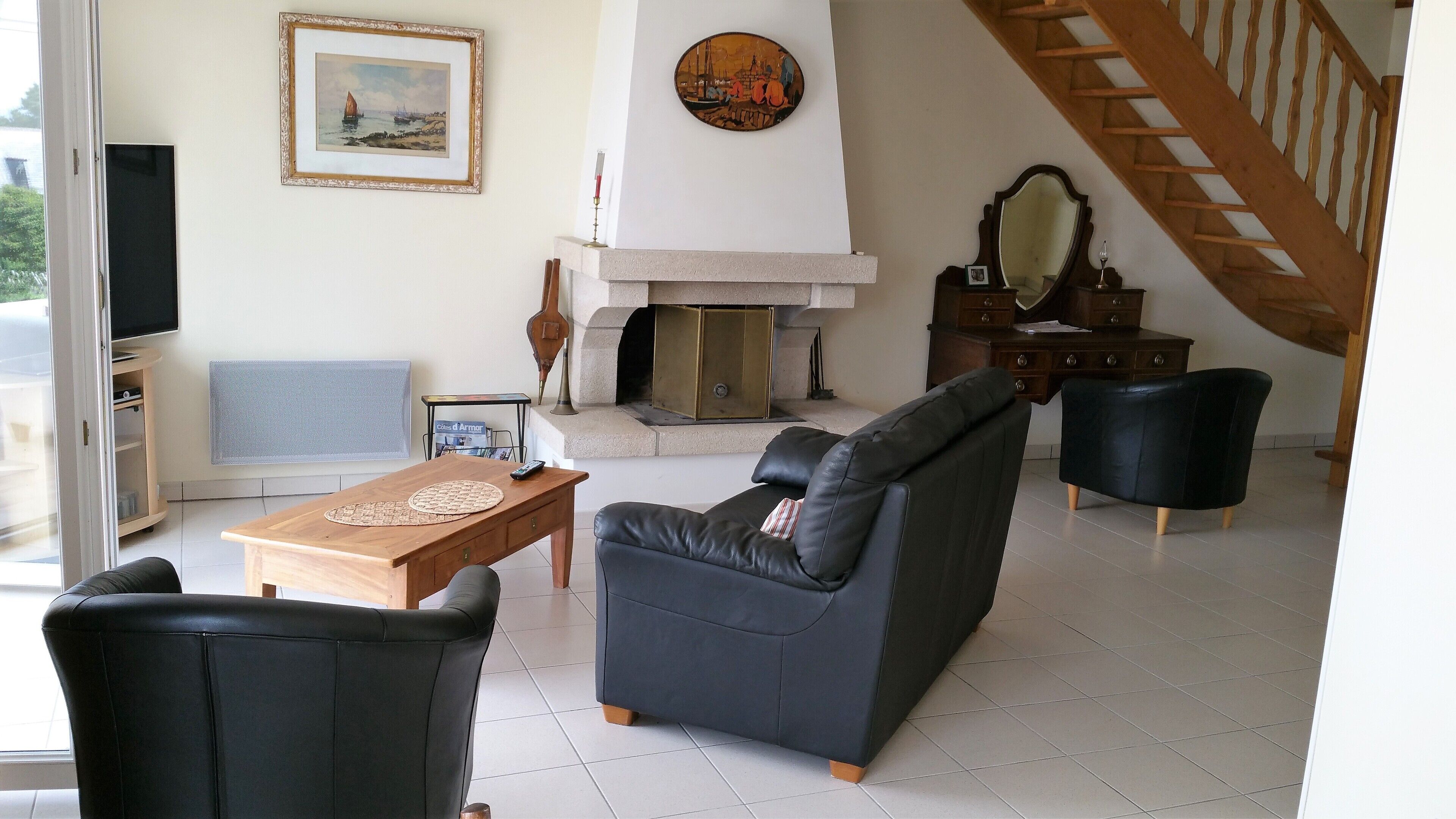 Un salon avec une cheminée, un canapé, une table basse et un téléviseur.