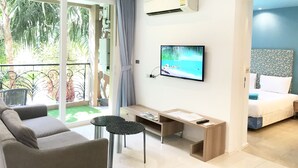 Una habitación de hotel moderna con balcón, cama, televisión, escritorio y sofá.