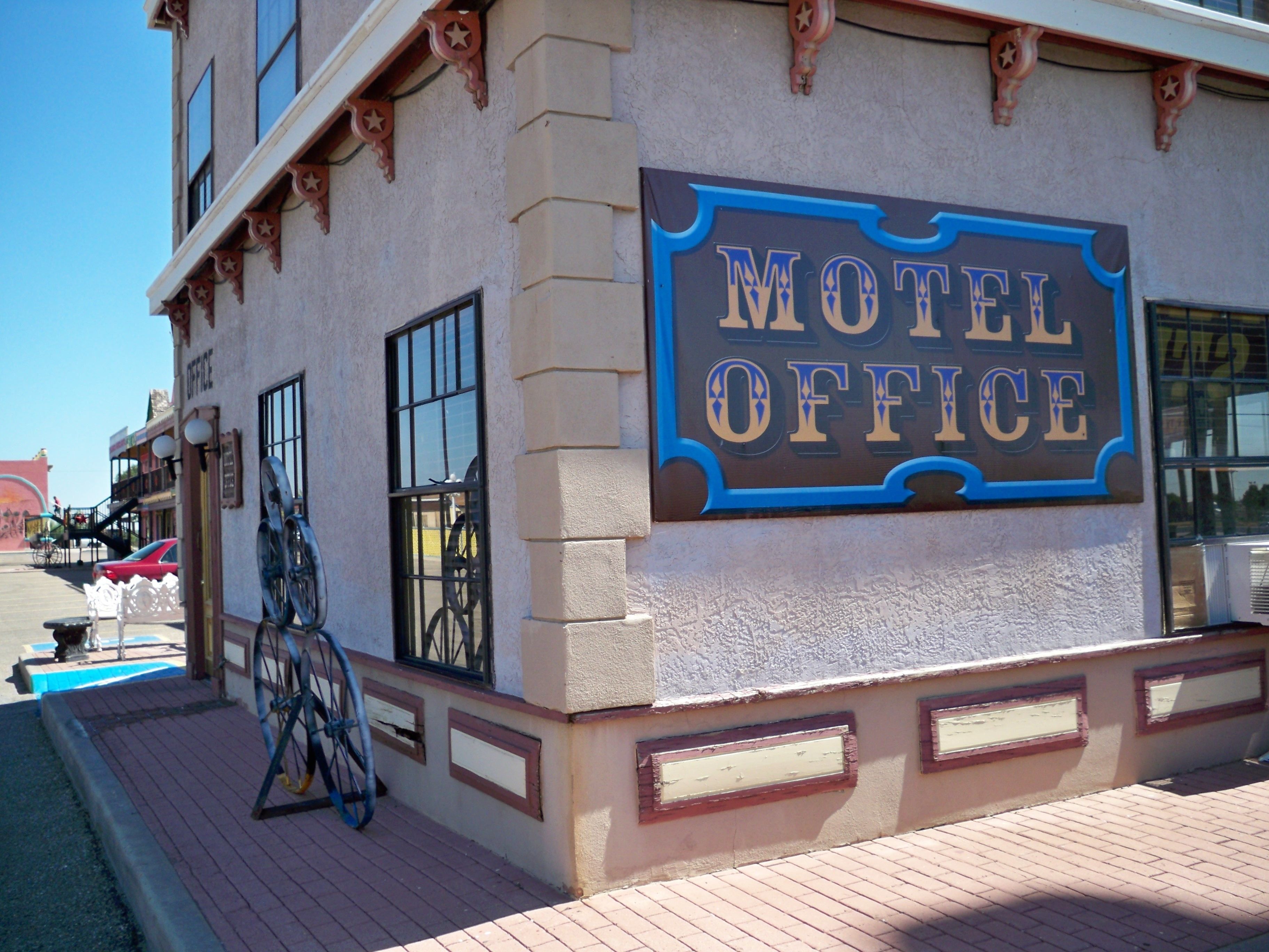 A building with a sign reading "Motel Office" and a bicycle parked outside.