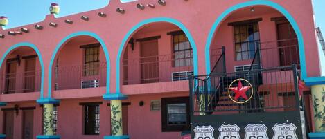 A pink building with blue trim and a sign indicating it is The Mother Road.