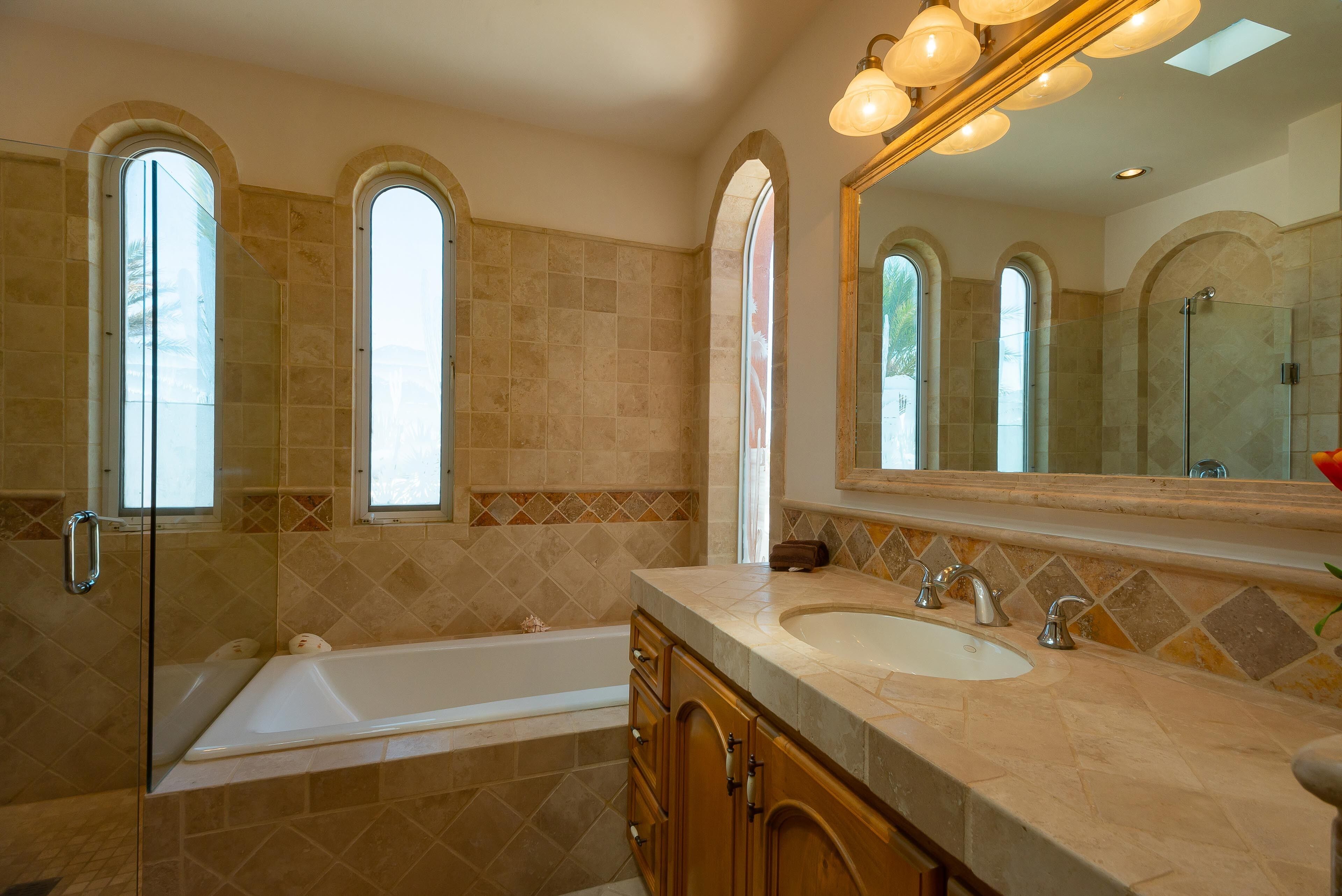 A bathroom with a bathtub, two sinks, and a large mirror.