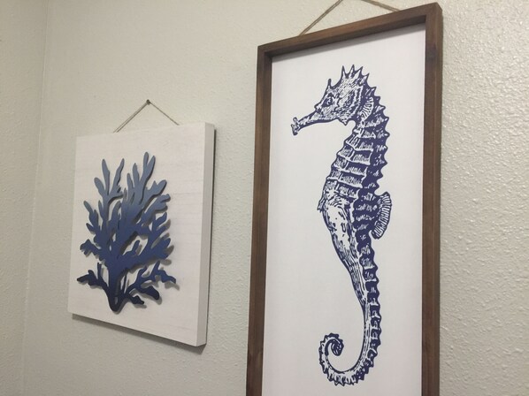 Two framed artworks on a wall: a blue coral-like structure and a detailed seahorse. - Our Cozy Getaway (Ocean Park)