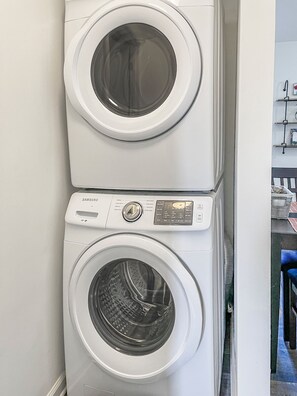 A stacked washer and dryer unit with control panel and buttons.