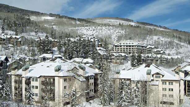 Ein schneebedecktes Resort mit mehreren Gebäuden, darunter ein großes Hotel mit Innenhof und einige kleinere Bauten.