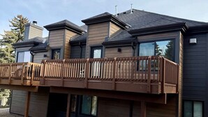A modern two-story house with a wooden deck and large windows. - Hidden Creek Ski Rentals (Park City)