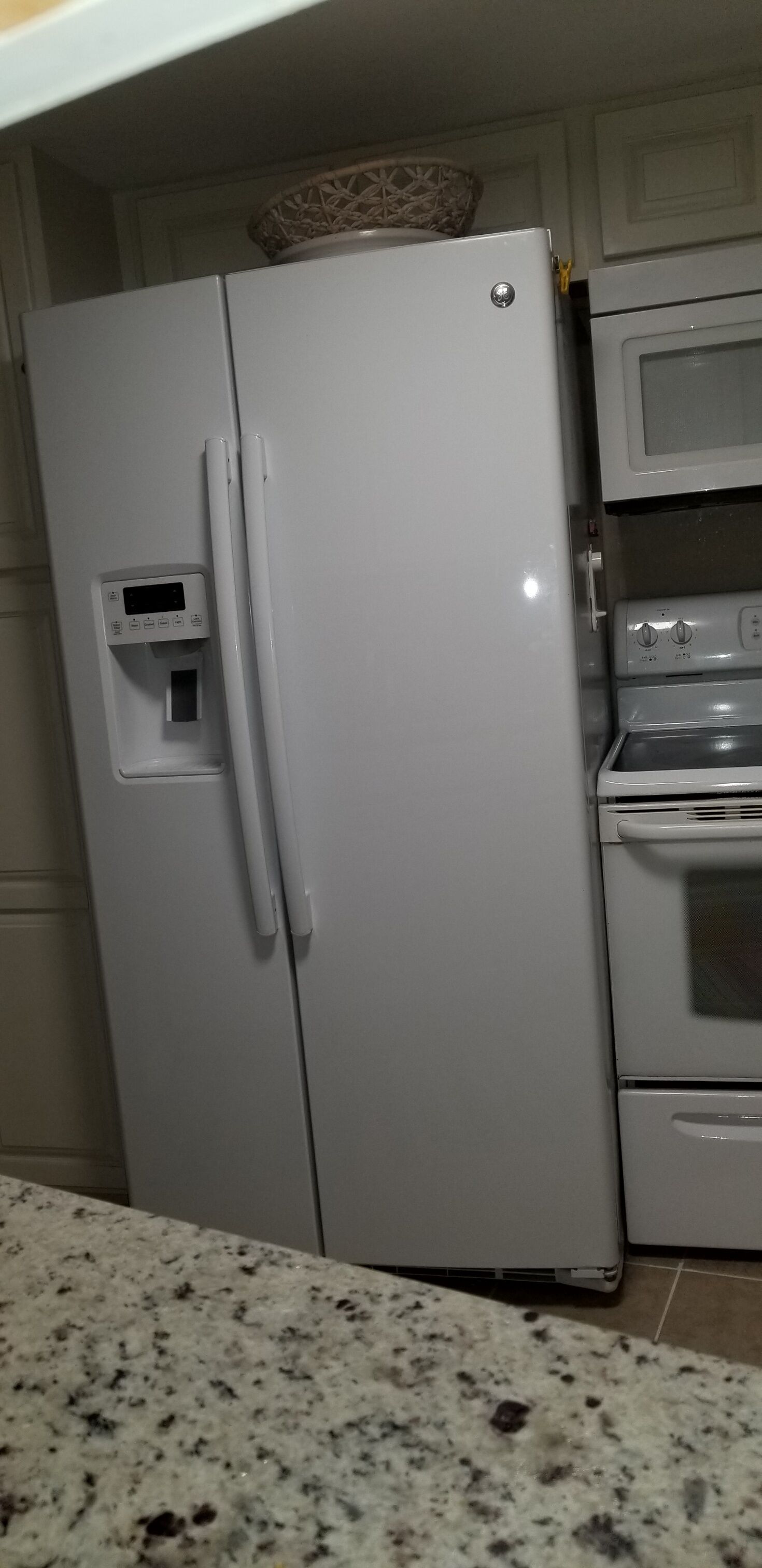 A kitchen with a white refrigerator, microwave, and oven.