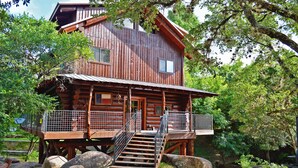 A wooden cabin with a balcony and a staircase leading to the entrance. - Lakefront•3BR/3.5BA+Loft•Hot Tub&Boat House (Burnet)