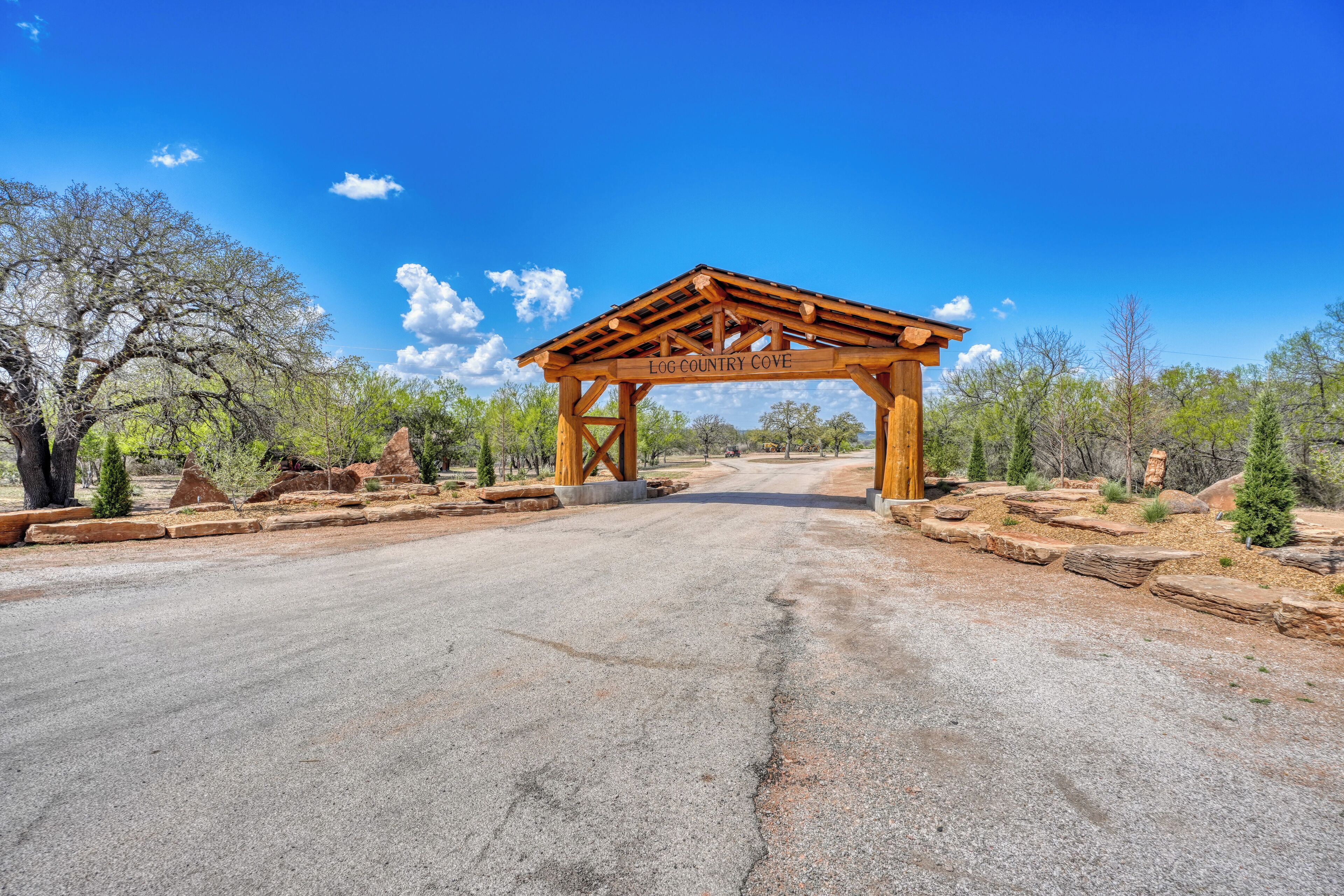 Une arche en bois portant l’inscription « LOG COUNTRY COVE », avec une route pavée qui passe en dessous.
