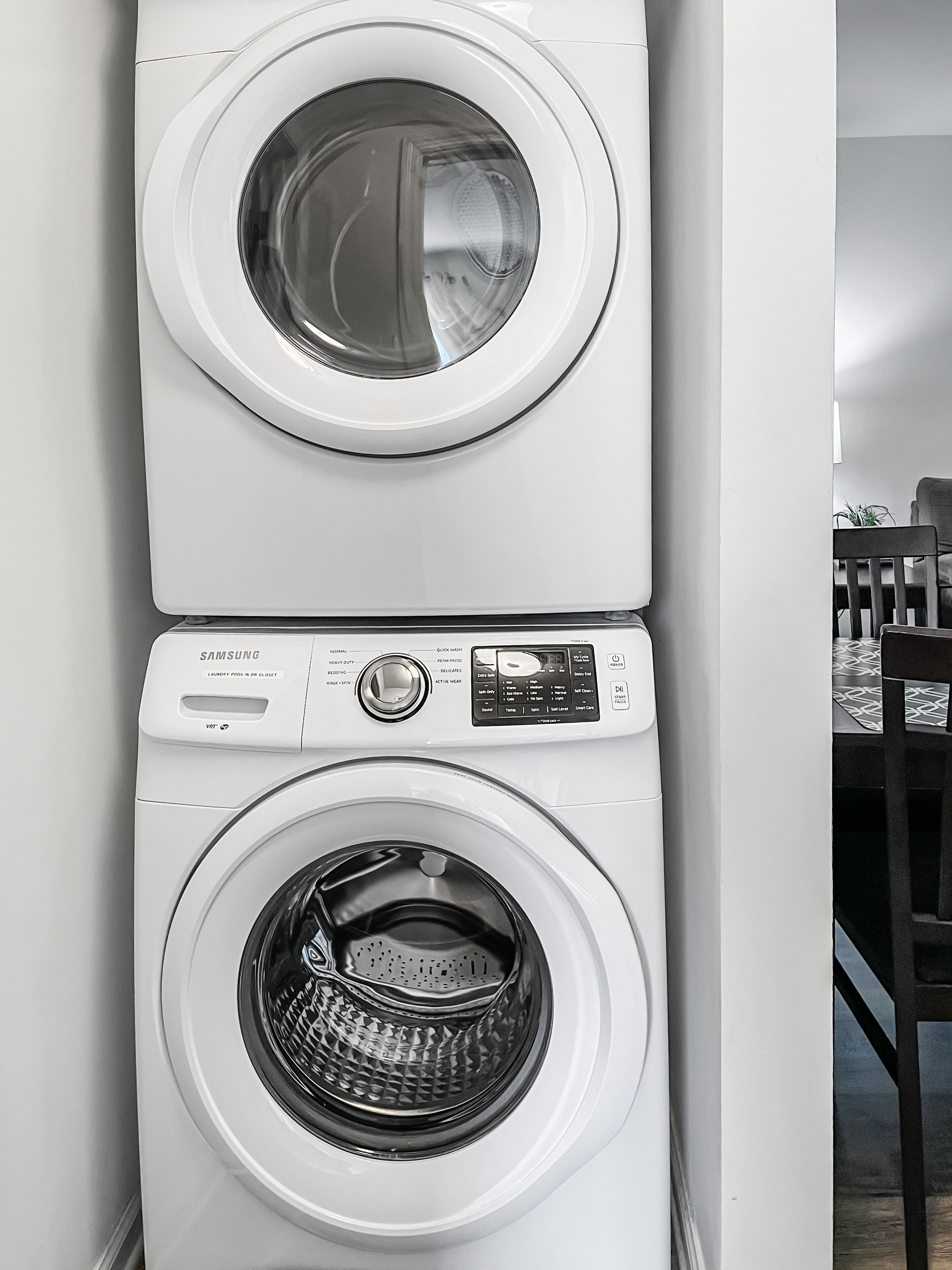 Una lavadora y secadora apiladas, con panel de control y botones.