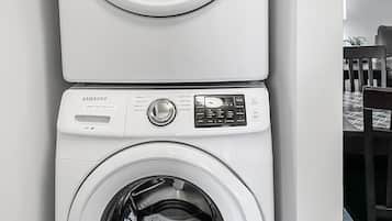 Una lavadora y secadora apiladas, con panel de control y botones.