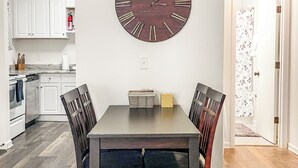 Un comedor con un reloj de pared redondo, una mesa y sillas.