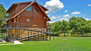 A wooden cabin with a balcony and a stone foundation.