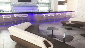Un área de bar moderna con asientos y una barra.