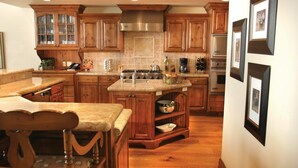 Una cocina amplia con armarios de madera, una isla central y un comedor con mesa y sillas de madera.