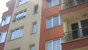 A multi-story residential building with balconies, large windows, and a flat facade. - Greek Rooms in the City Center (Sofia)