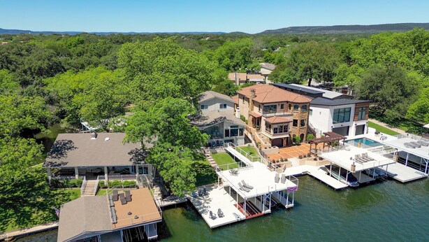 A waterfront property with multiple buildings, a dock, and a swimming pool.