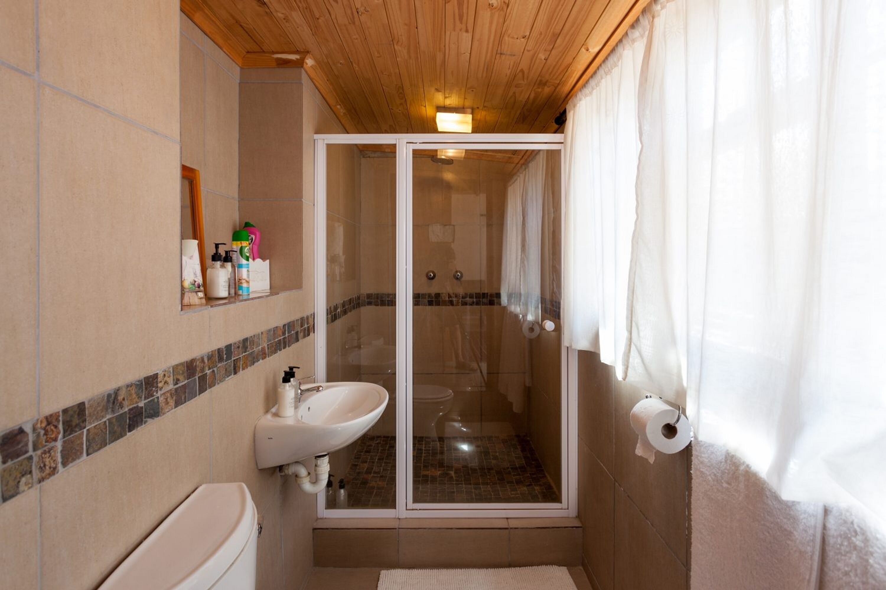 Un bagno con doccia, WC e lavandino.