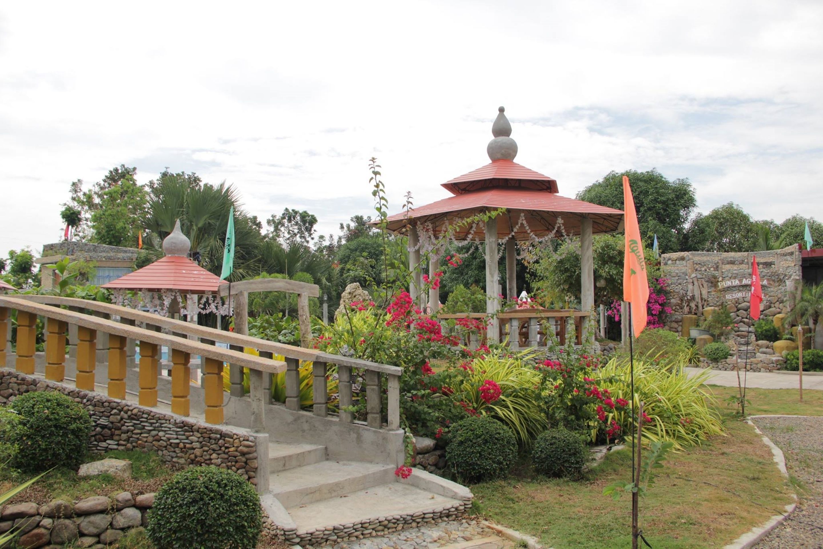 Ein Garten mit einem Pavillon, Steintreppen und einer Steinmauer.