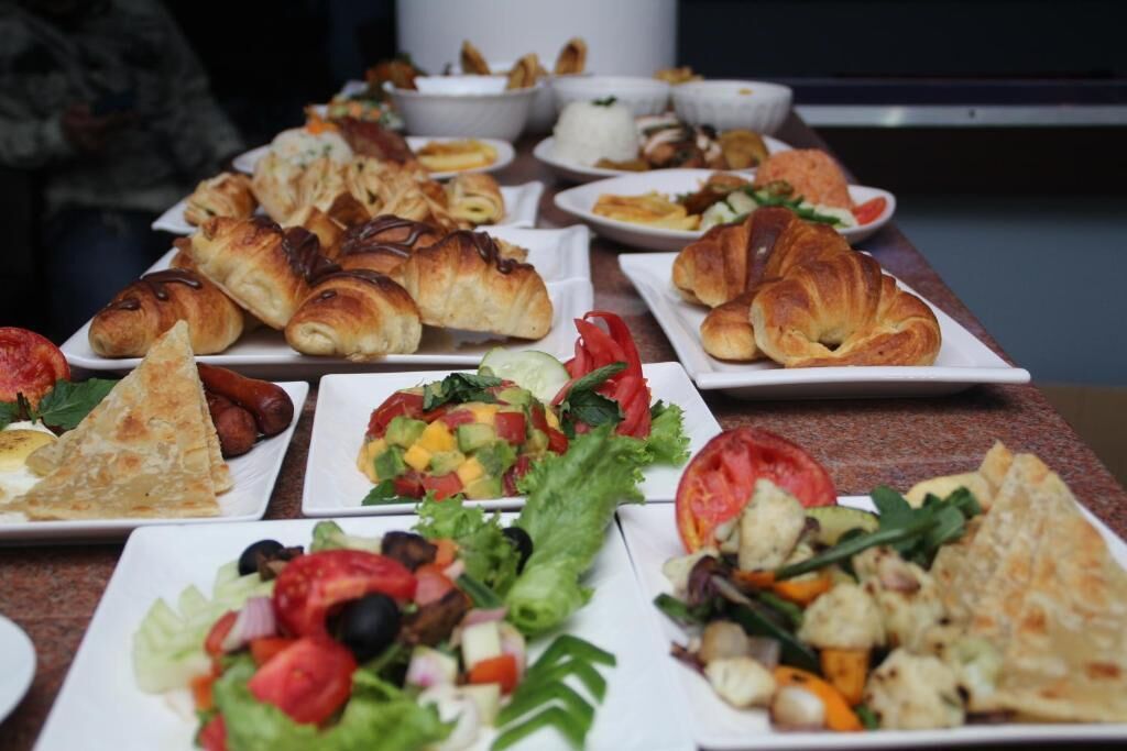 A variety of breakfast items including croissants, salads, and other dishes on a table.