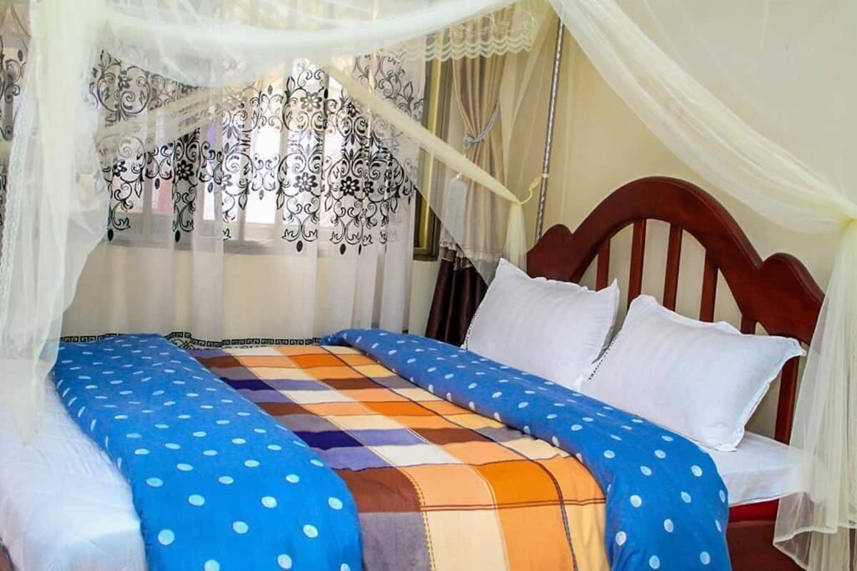 A bed with a blue polka dot bedspread, white pillows, and a wooden headboard.