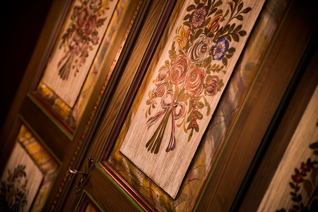 A close-up of a wooden panel with floral carvings.