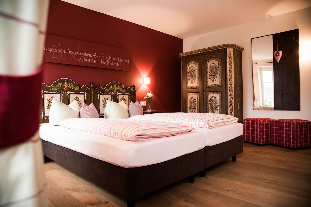 A bedroom with a large bed, a wardrobe, and a mirror.