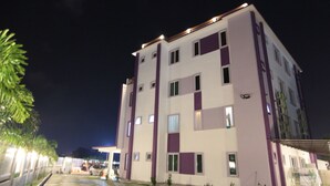 Um edifício de vários andares com telhado plano e várias janelas.
