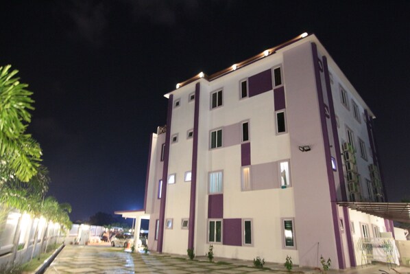 Un edificio de varios pisos con techo plano y una serie de ventanas.