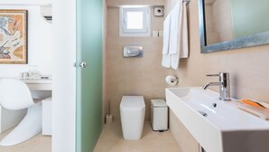 A modern bathroom with a white sink, a mirror, and a toilet. There is a small window above the toilet and a towel hanging on the wall. - ALC Best View in Athens (Athens)