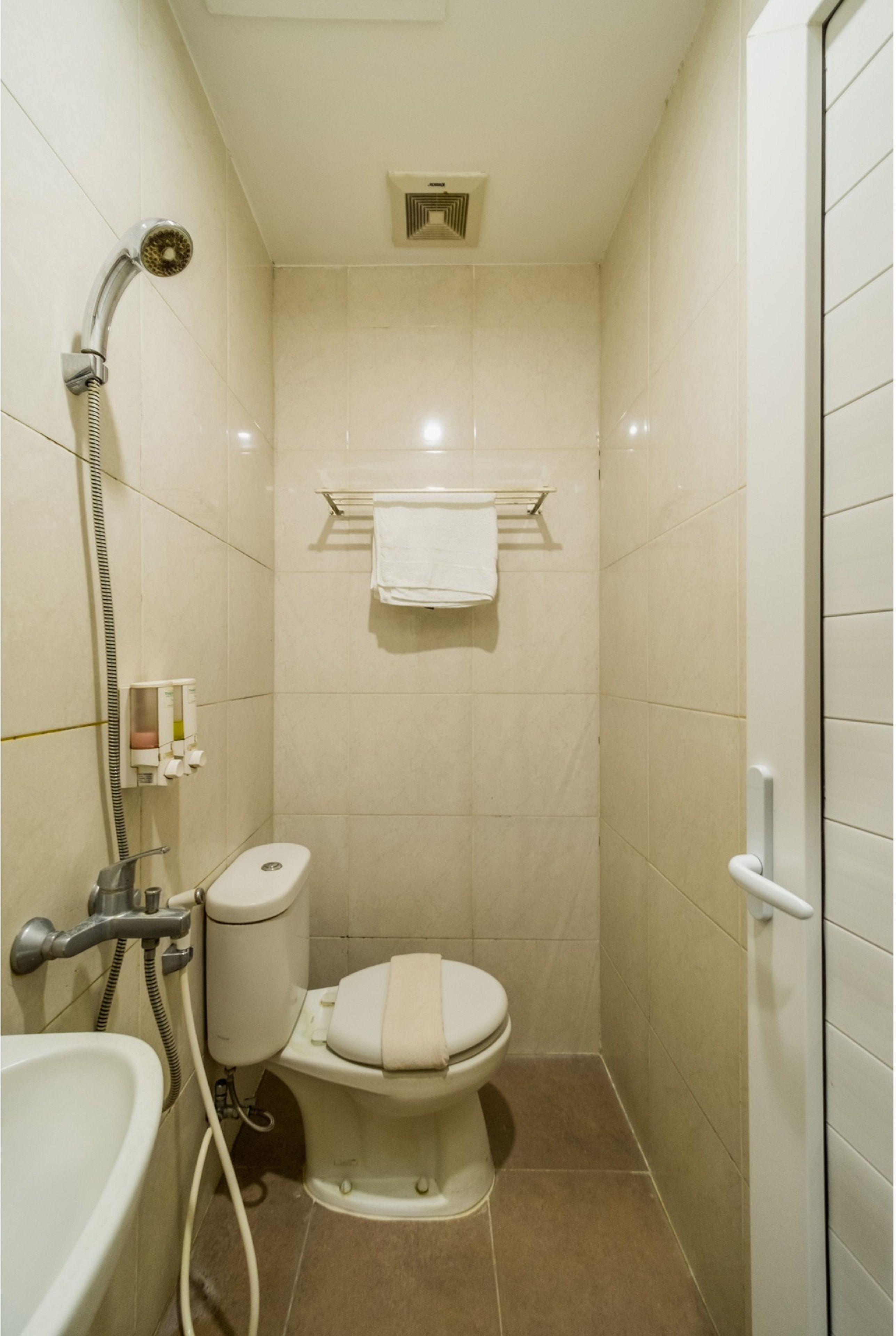 A small, modern bathroom with a toilet, a shower, and a sink.