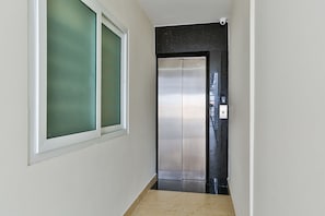Experience the sleek, modern design of this contemporary elevator, complete with a control panel and display.