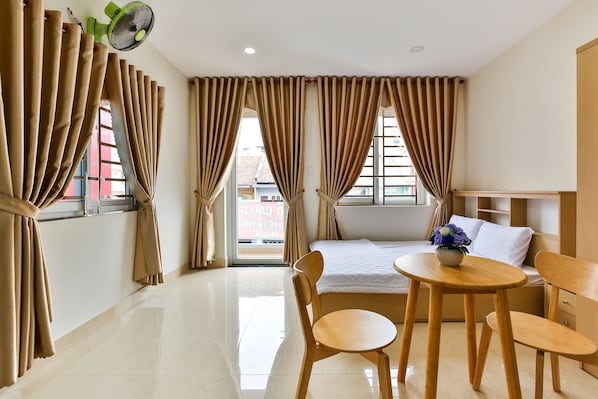 Enjoy a restful stay in this stylish room with a made bed, dining table, and side table.
