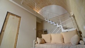 A modern interior with a staircase, a sofa, and a door. - Comera (Matera)