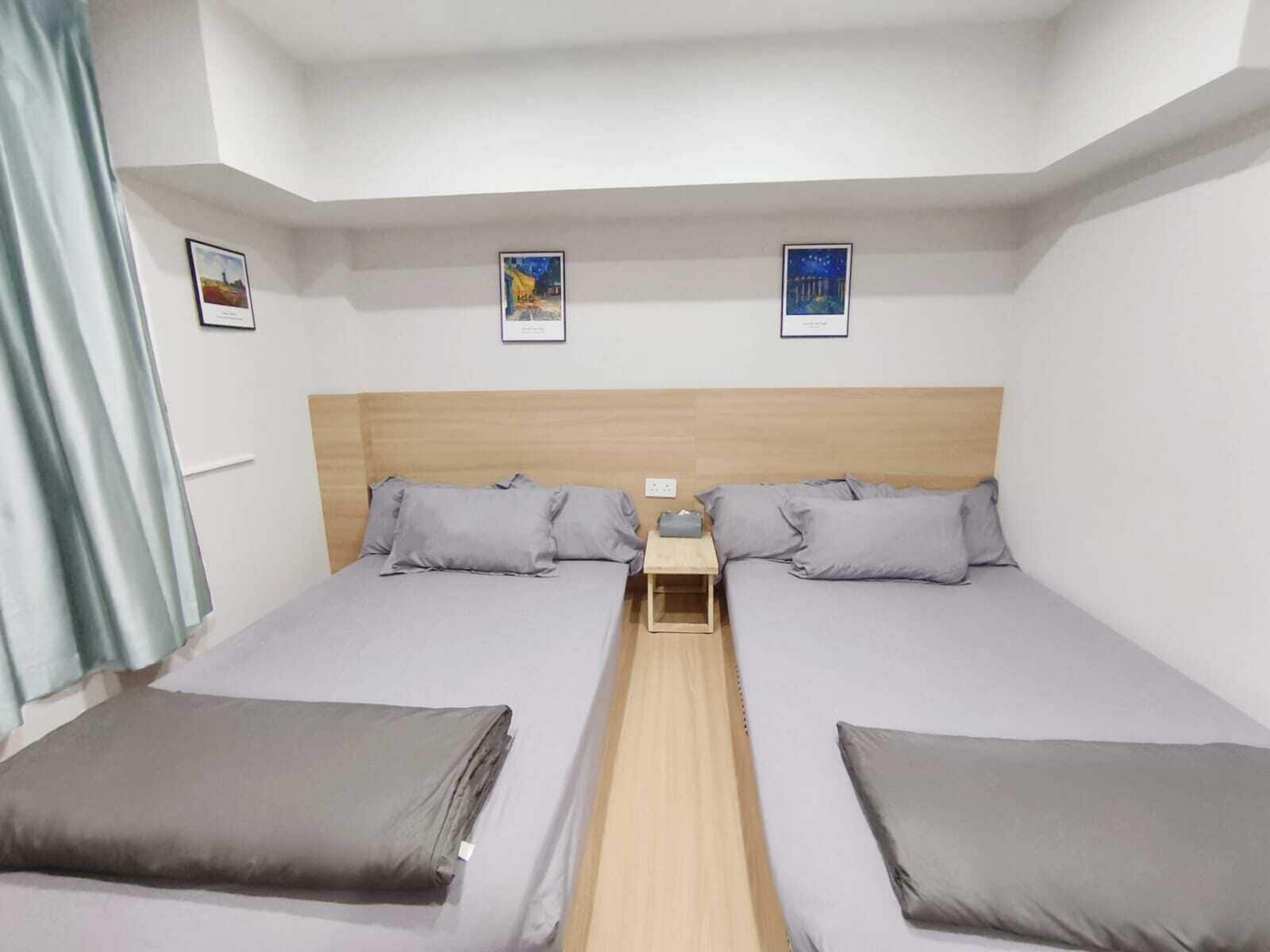 Habitación doble con dos camas, cabecera de madera, mesita de noche y ventana con cortinas.
