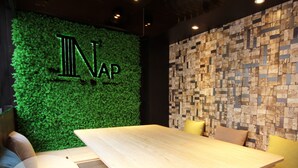 A modern interior with a green wall displaying the letters "NAP" and a mosaic wall. - The Nap Tsim Sha Tsui (Kowloon)