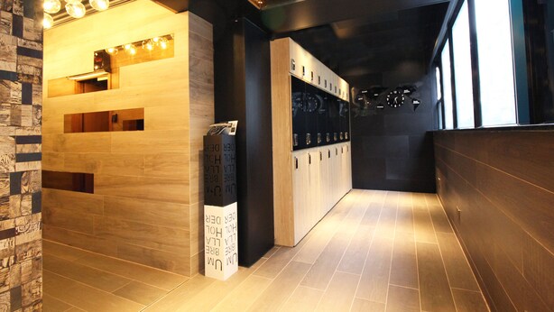 A modern reception area with wooden reception desk, a digital display, and a wall-mounted bike rack. - The Nap Tsim Sha Tsui (Kowloon)