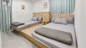 A room with two beds, a small table, and a window with curtains. - The Nap Tsim Sha Tsui (Kowloon)