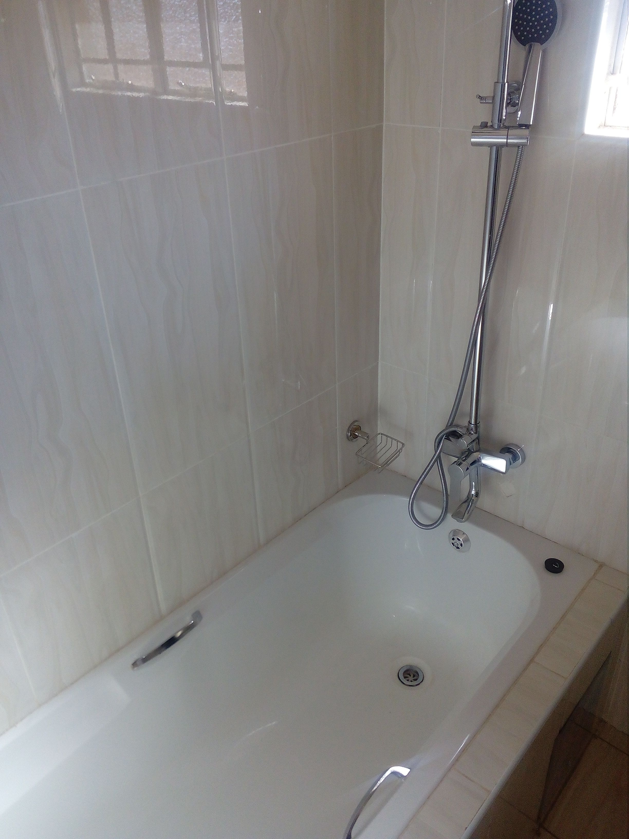 Ein Badezimmer mit einer weißen Badewanne, einer Duschbrause und einer Handbrause.