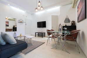 Deluxe-Apartment, Mehrere Betten, Nichtraucher, Stadtblick | Wohnbereich | Plasmafernseher