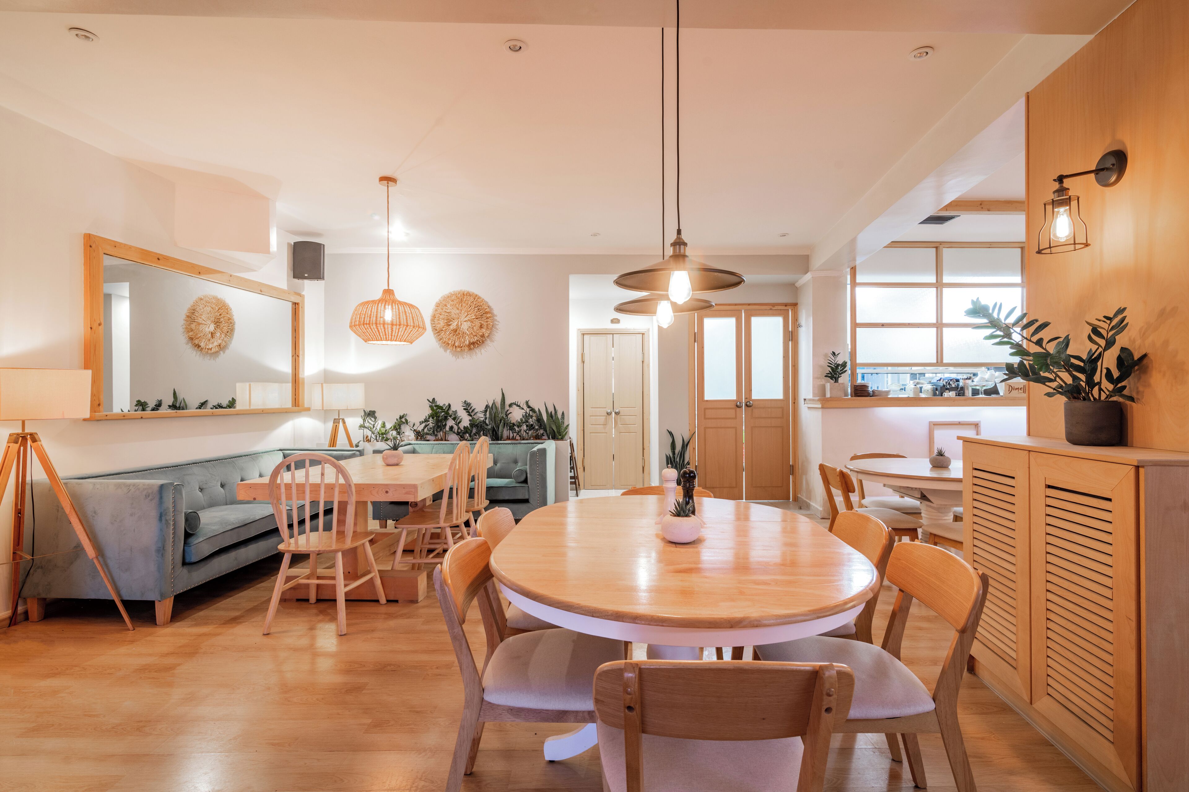A modern dining area with a round wooden table, wooden chairs, and pendant lighting.