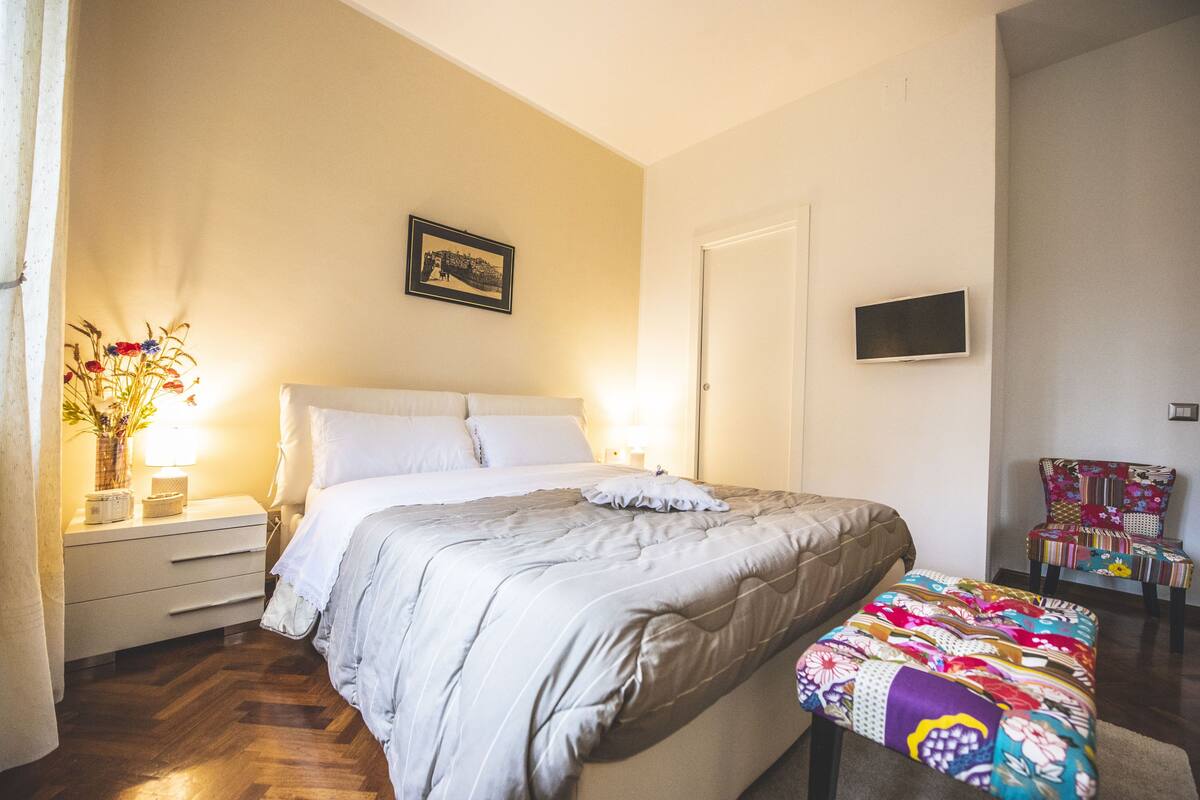 Une chambre à coucher avec un lit, une table de chevet, une lampe et une chaise.