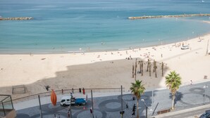 A beach with a clear view of the sea, a sandy shore, and a few palm trees. - Front of Beach -Luxurious Residence (Tel Aviv)