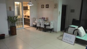 Una sala de estar moderna con comedor, un sofá, una mesa de centro y un cartel con texto.