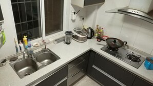 Una cocina con un lavamanos doble, una estufa, un hervidor y varios electrodomésticos.