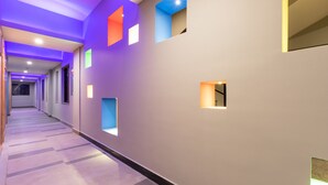 A modern hallway with recessed lighting and geometric wall cutouts.