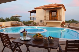 Una piscina al aire libre, sombrillas, sillones reclinables de piscina